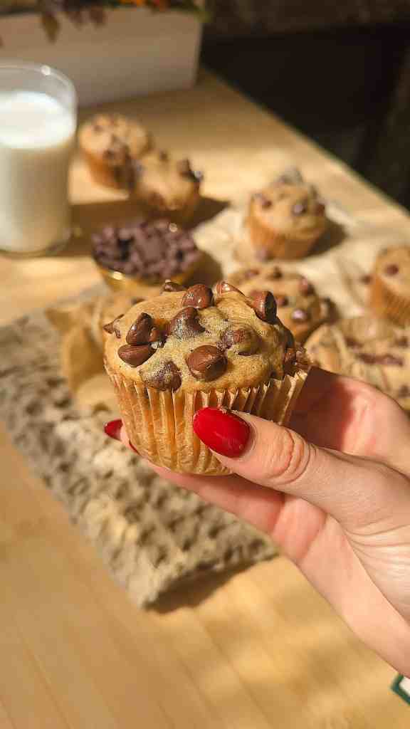 a close up of a fresh brown butter banana muffins to show off the gooey chocolate chips