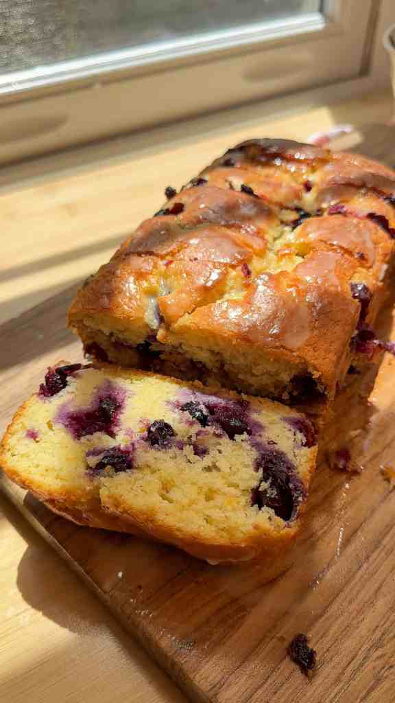 sliced up lemon blueberry bread on a cutting board ready to be enjoyed