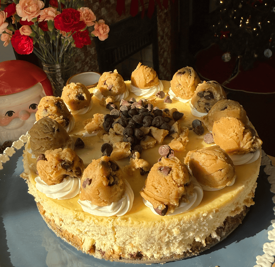 freshly decorated chocolate chip cookie cheesecake on a cake stand