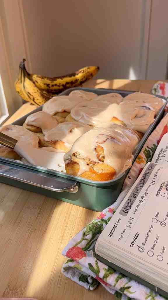 a full pan of fresh out of the oven banana bread cinnamon rolls with a maple cinnamon glaze