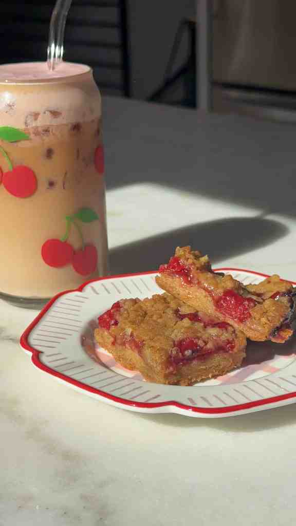 my cherry pie bars on a colorful plate with a cherry coffee ready to be enjoyed