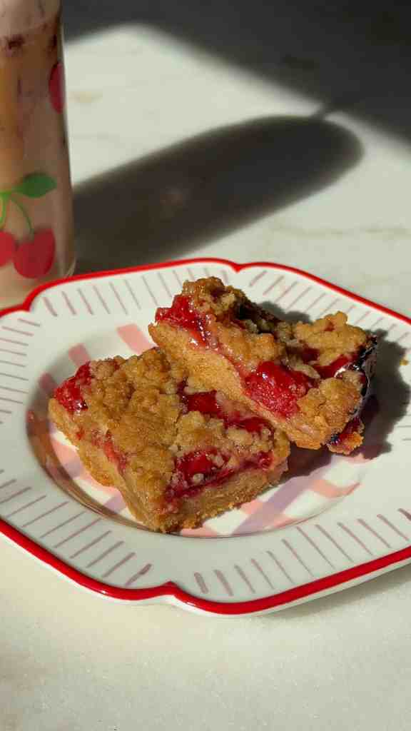my cherry pie bars on a colorful plate with a cherry coffee ready to be enjoyed