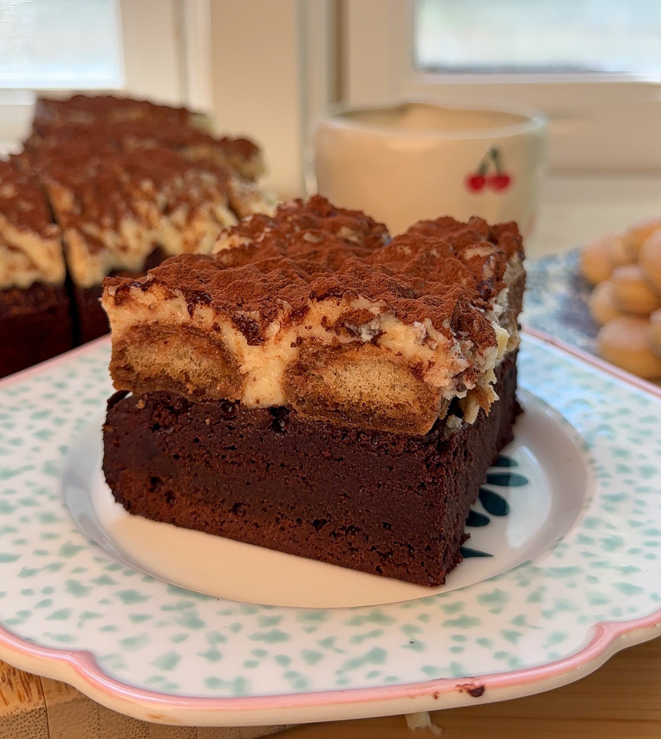 a slice of my brown butter tiramisu brownies on a colorful plate with coffee in the background