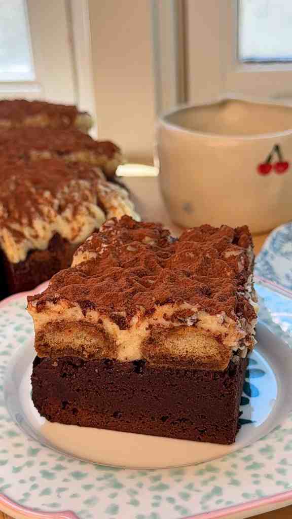 a slice of my brown butter tiramisu brownies on a colorful plate with coffee in the background